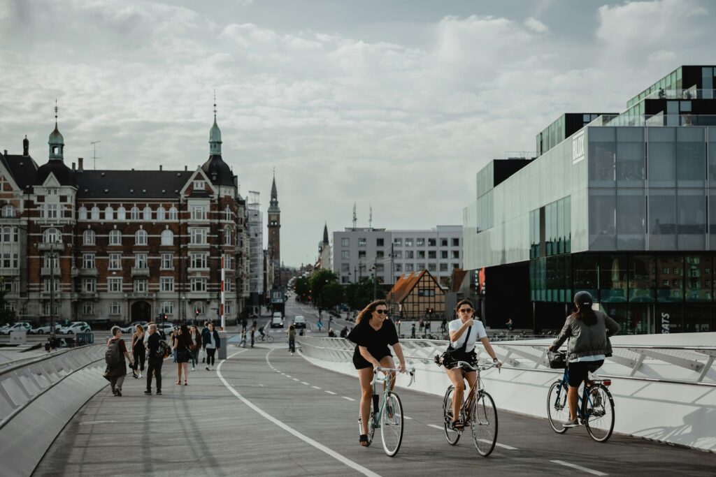 People cycling and walking on a pathway near buildings