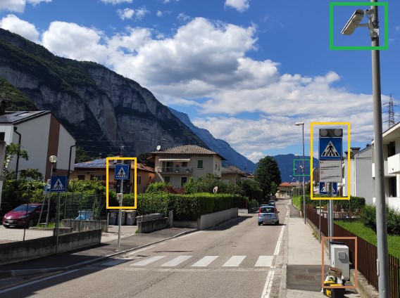 The same pedestrian crossing in Trento after the pilot, with a pole-mounted camera, illuminated crossing signs and a roadside edge-computing unit highlighted
